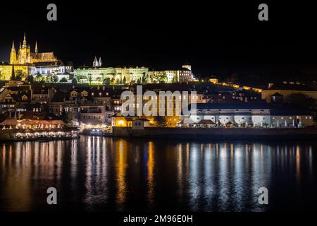 Vista dal ponte Carlo attraverso il fiume Moldava fino al castello di notte. Foto Stock