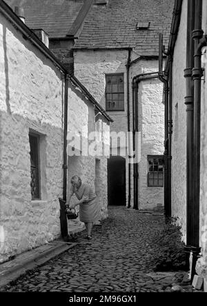 Una donna che riempie un bollitore da un rubinetto all'aperto a Newhaven, East Sussex. Foto Stock