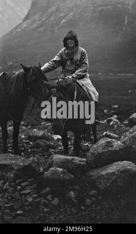 Donna fuori a cavallo con due pony in una giornata piovosa a Portree, Isola di Skye, Scozia. Foto Stock