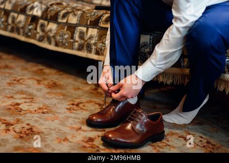 la tuta con i lacci si adatta alle classiche scarpe marroni Foto Stock