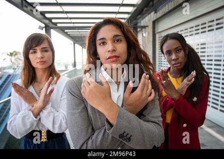 Tre donne con le braccia incrociate rompono il movimento Bias a sostegno della Giornata internazionale della donna Foto Stock