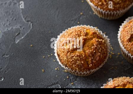 Deliziosi muffin fatti in casa alla zucca con crosta di zucchero piccante con latte su sfondo nero testurizzato, spazio, vista dall'alto Foto Stock