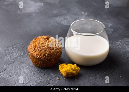 Deliziosi muffin fatti in casa alla zucca con crosta di zucchero piccante con latte su sfondo nero testurizzato, spazio, vista dall'alto Foto Stock