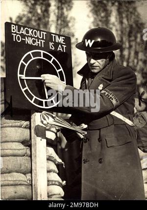 Un Air RAID Warden regola l'indicatore del tempo di blackout presso un ARP Post vicino a Londra nel 1939. Foto Stock