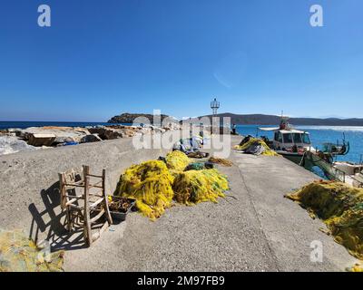 Plaka, Creta, Grecia - 10 ottobre 2022: Turisti non identificati sul molo con vista sulla vecchia Fortezza Veneziana Spinalonga, precedentemente utilizzata come lebbra statio Foto Stock