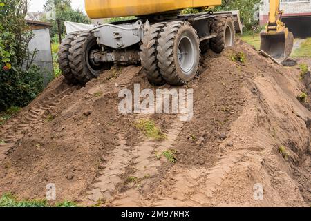 Tracce dal battistrada del pneumatico sul retro dell'escavatore per trasporto industriale o dell'apripista gommato. Foto Stock