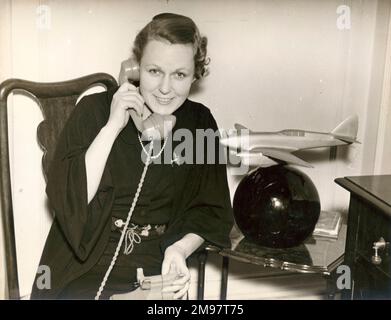 C.W.A. La seconda moglie di Scott, Greta, riceve messaggi di congratulazioni dopo la vittoria della gara di Schlesinger Portsmouth a Johannesburg. 1 ottobre 1936. È accanto a un modello del de Havilland DH88 Comet Racer in cui Scott ha vinto il MacRobertson London a Melborne Air Race nel 1934. Foto Stock