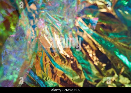 Colori olografici non focalizzati della lamina di madreperla. Lamina iridescente sminuzzata con una vera texture. Sfondo astratto olografico iridescente. Foto di alta qualità Foto Stock