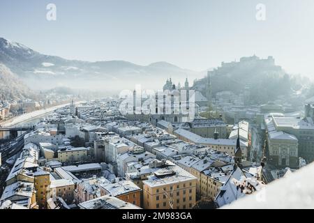 Paesaggio urbano e skyline con la Cattedrale di Salisburgo e la Fortezza di Hohensalzburg nella neve d'inverno, Salisburgo, Austria Foto Stock