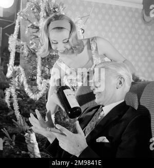 Pubblicità per lo sherry dell'emu -- modelli maschili e femminili che si presentano nella scena del partito di Natale. Foto Stock