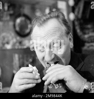 Pubblicità per il cioccolato di Cadbury -- modello maschile (Jack Todd) in posa in un negozio di antiquariato. Foto Stock