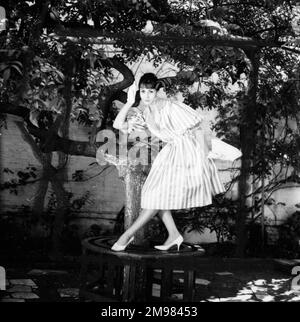 Giovane donna (modello - collina di Geraldine) modellante un vestito in un giardino. Foto Stock