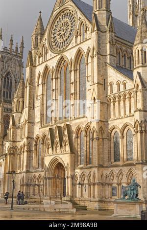 L'ingresso sud della cattedrale di York con una statua dell'imperatore romano Costantino in primo piano. Un sole invernale illumina la scena. Foto Stock