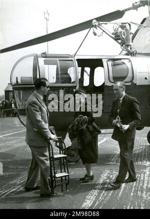G.P. maggiore Bulman, CBE, FRAeS, presidente della Royal Aeronautical Society 1950-1951 e sua moglie arrivano al 1951 Royal Aeronautical Society Garden Party presso il White Waltham Aerodromo il 6 maggio da un Westland S51 volato da D. Colvin. Foto Stock