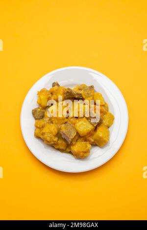 Stufato di manzo con patate dolci e salsa al curry sul piatto Foto Stock