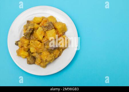 Stufato di manzo con patate dolci e salsa al curry sul piatto Foto Stock