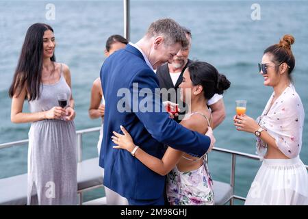 Uomo d'affari e ragazza amico in vacanza a vela sullo yacht proposto sposarsi Foto Stock