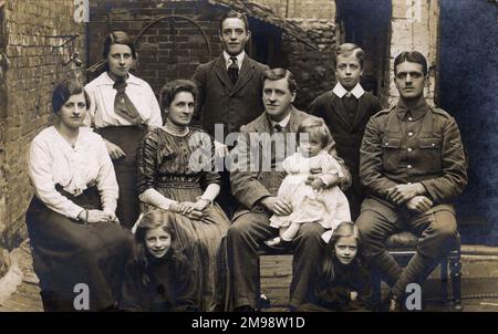 Una foto toccante e appuntita del gruppo della famiglia Ritratto nel loro cortile - otto bambini - il ragazzo più anziano è apparentemente appena fuori per combattere per il suo paese nel WW1. Foto Stock