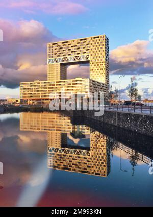 Il Pontsteigergebouw si rifletteva sull'acqua di Amsterdam, nei Paesi Bassi. Un moderno punto di riferimento architettonico sul lungomare. Foto Stock
