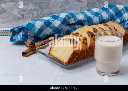 Pane di banana noce a fette accompagnato da un bicchiere di latte. Foto Stock