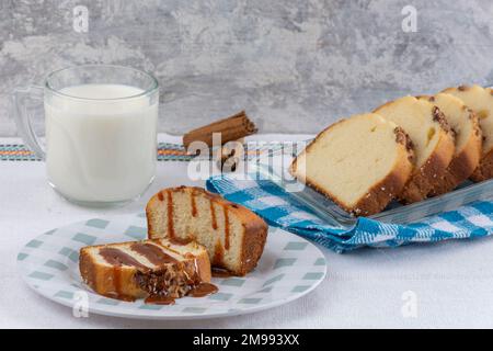 due fette di pane di noce con cajeta su un tavolo accompagnato da un bicchiere di latte. Foto Stock