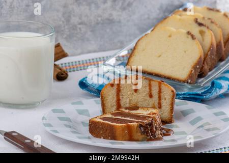 primo piano di pane di noce con cajeta su un piatto, accompagnato da un bicchiere di latte. Foto Stock