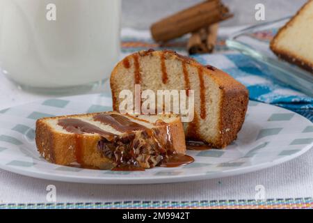 primo piano di pane di noce con cajeta su un piatto, accompagnato da un bicchiere di latte. Foto Stock