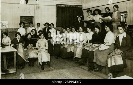 Donne che fanno sacchi e abiti caldi per le truppe in una capanna YMCA durante la prima guerra mondiale. Foto Stock