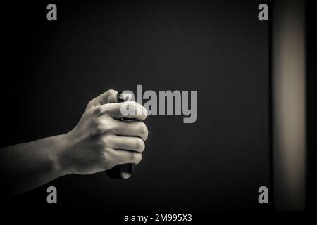Una mano maschio con un telecomando in bianco e nero Foto Stock