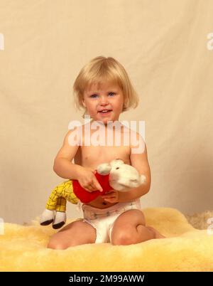 Ragazza toddler che tiene l'orso del toddy nell'ambiente di studio, Londra grande, Inghilterra, Regno Unito Foto Stock