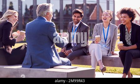 Il team di business multiculturale che siede fuori dall'ufficio per una pausa caffè ha un incontro informale Foto Stock