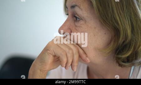 Donna anziana penosa che ascolta la conversazione Foto Stock