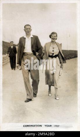 Una giovane coppia che si snoda lungo il lungomare di Bridlington, East Yorkshire. Foto Stock