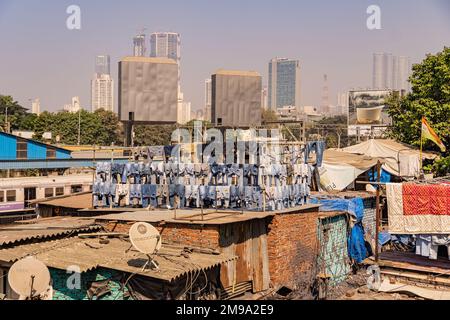 Incredibile vista del Dhobi Ghat a Mumbai, la lavanderia all'aperto più grande del mondo. Impressionante contrasto sociale con i grattacieli dello skyline. Foto Stock