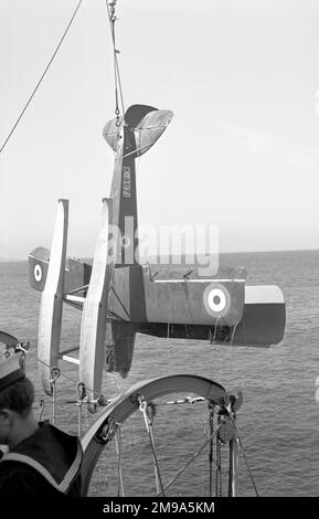 Royal Navy - de Havilland DH.82 Queen Bee K8671 (msn 5204), in fase di recupero da parte dell'incrociatore HMS Newcastle dopo una pratica di armi da fuoco anti-aerei. Il Queen Bee era un drone bersaglio radiocontrollato che utilizzava ali Tiger Moth, con la fusoliera in legno del DH.60 Moth per migliorare la galleggiabilità in caso di arrivo e migliorare la resistenza alla corrosione. Foto Stock