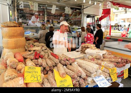 Il venditore italiano di salame nella sua bancarella di mercato. Foto Stock