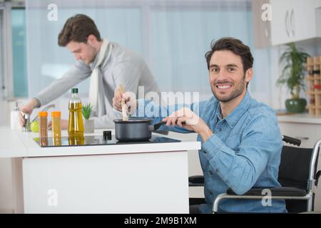 felice uomo disabile sta cucinando la pasta Foto Stock