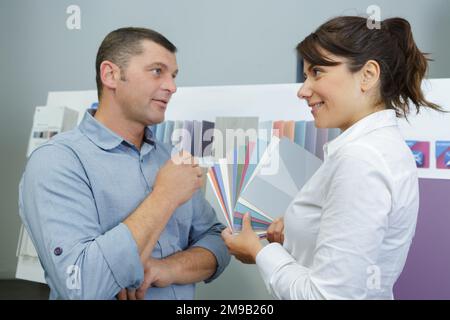 donna deve scegliere il colore per la parete in appartamento Foto Stock