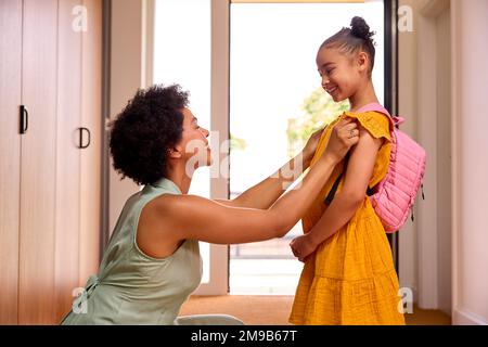 Madre a casa aiutare figlia prepararsi per andare a scuola Foto Stock