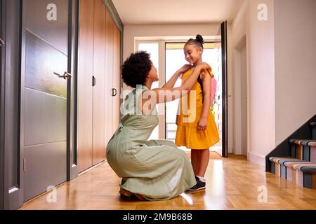 Madre a casa aiutare figlia prepararsi per andare a scuola Foto Stock