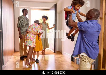 Famiglia Multi-generazione con nonni saluto i nipoti in corridoio a casa Foto Stock