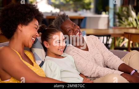 Multi-generazione Famiglia femminile relax seduta sul divano a casa insieme Foto Stock