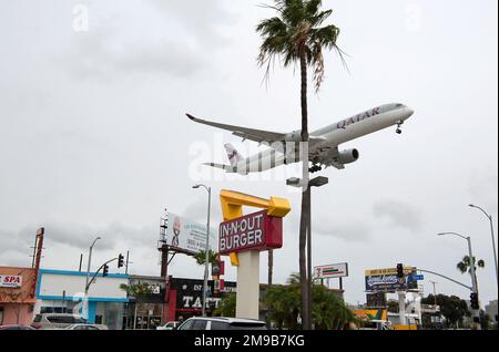 Un aereo Qatar Airlines sta per atterrare all'aeroporto LAX, proprio accanto a un ristorante fast food in-N-out Burger a Los Angeles, California Foto Stock