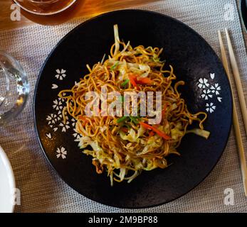 Tagliatelle in stile giapponese con verdure yakisoba splendidamente servite nella ciotola Foto Stock