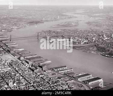 1950S 1960S AEREO CHE GUARDA A NORD SUL FIUME DELAWARE, PASSATO IL PONTE BEN FRANKLIN E I PONTILE SUL LUNGOMARE DI PHILADELPHIA, PA USA - A1197 HAR001 HARS BOUNDARY, FRONTE MARE DEL FIUME DELAWARE, BIANCO E NERO, HAR001 IN VECCHIO STILE Foto Stock