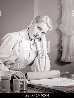 1940S 1950S DISGRUNTLED ATTRAENTE BIONDA DONNA CASALINGA GUARDANDO LA MACCHINA FOTOGRAFICA IN CUCINA CHE ARROTOLA VERSO L'ESTERNO PASTA DI CROSTA DI TORTA - H1688 HAR001 HARS COMUNICAZIONE BIONDA GIOVANE ADULTO PREOCCUPAZIONE LIFESTYLE FEMMINE MOODY HOME VITA COPIA SPAZIO METÀ LUNGHEZZA SIGNORE PERSONE ESPRESSIONI DISTURBATE B&W INTERESSATI TRISTEZZA OCCHIO CONTATTO CASALINGA SOGNI CASALINGHE MOOD TORTA CROSTA CONCETTUALE GLUM FUGA ROLLING PIN IDEE ALLA MODA MISERABILE GIOVANE ADULTO DONNA NERO E BIANCO ETNICITÀ CAUCASICA HAR001 VECCHIO STILE Foto Stock