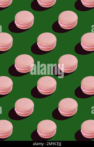 motivo senza cuciture di biscotti al macaroon rosa su sfondo verde Foto Stock