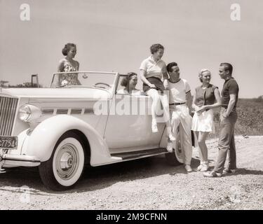 1930S GRUPPO DI AMICI UOMINI E DONNE IN GIRO PER UN'AUTO CONVERTIBILE TUTTI INDOSSANDO ABITI SPORTIVI ESTIVI CASUAL PARLANDO E SORRIDENDO - M5596 HAR001 HARS LIFESTYLE FEMMINE RURAL HEALTHINESS 6 LUSSO COPIA SPAZIO AMICIZIA FULL-LENGTH MEZZA-LENGTH SIGNORE PERSONE AUTO MASCHI SEI TRASPORTO B & W ESTATE TEMPO OFF SHORE FELICITÀ AVVENTURA TEMPO LIBERO VIAGGIO SPORTIVO E AUTOS FUGA RICREAZIONE SPIAGGE VACANZE HIGH TECH CONNESSIONE AUTOMOBILI AMICHEVOLE SABBIA ELEGANTE VEICOLI COOPERAZIONE METÀ-ADULTO RELAX STAGIONE VACANZE TOGETHERNESS GIOVANE UOMO ADULTO GIOVANE DONNA NERO E BIANCO CASUAL Foto Stock