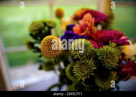 Bouquet luminoso e colorato di fiori su tavolo per finestra Foto Stock