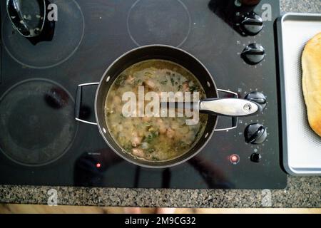 Grande pentola di zuppa di cottura su piano cottura in cucina Foto Stock